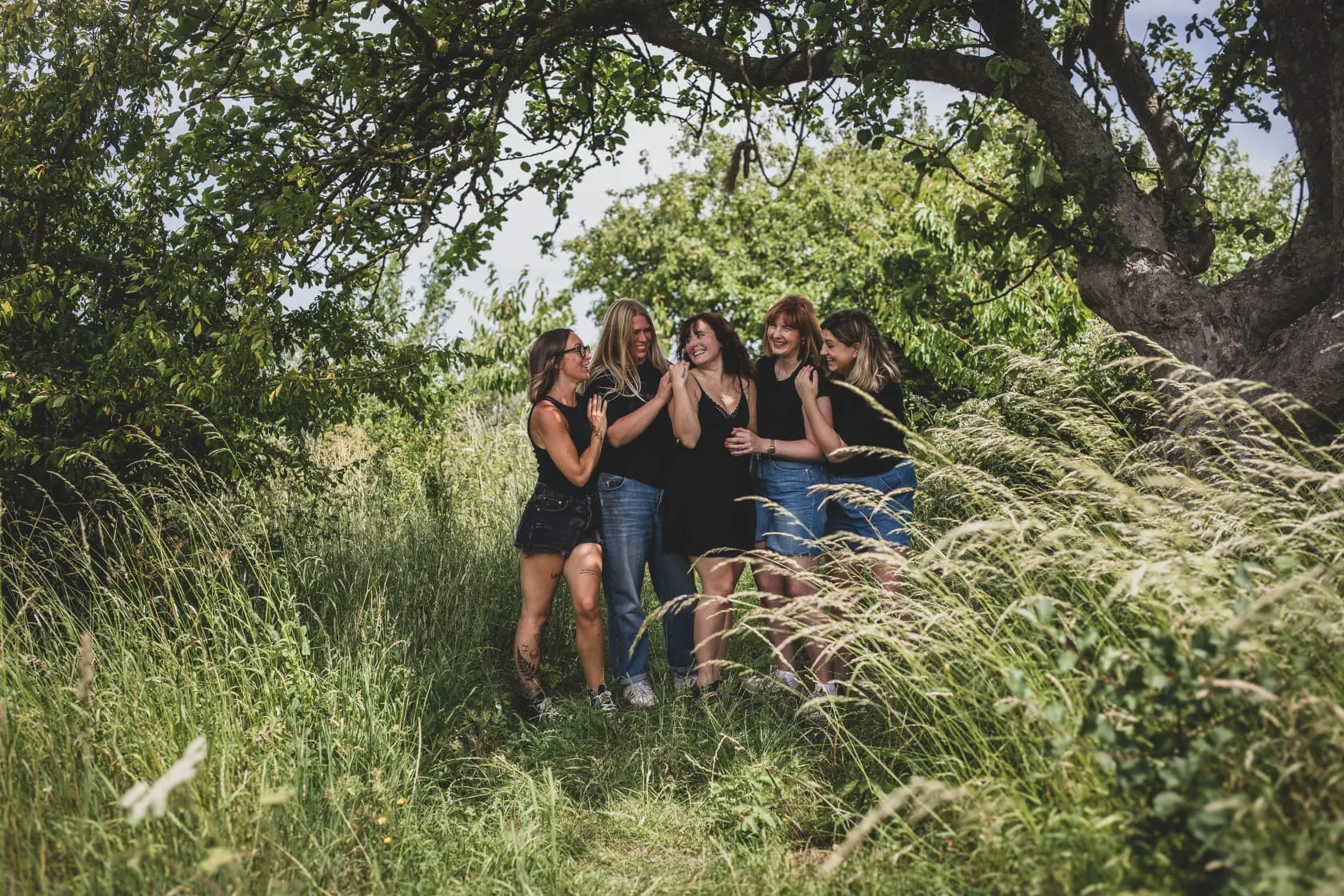 The Laurenne Hopkins Flowers team standing together under orchard trees