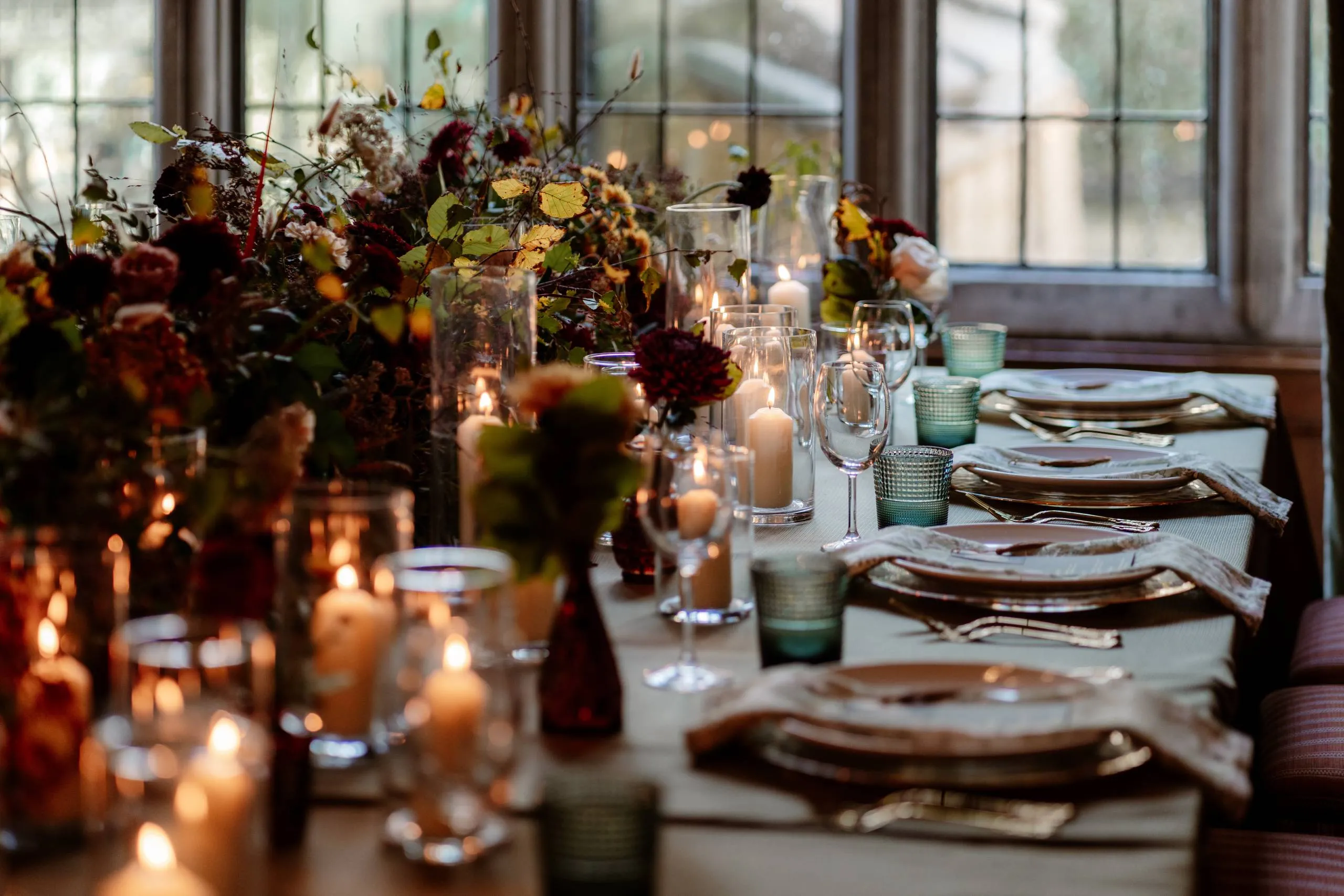 An autumn wedding table with candles and seasonal flowers