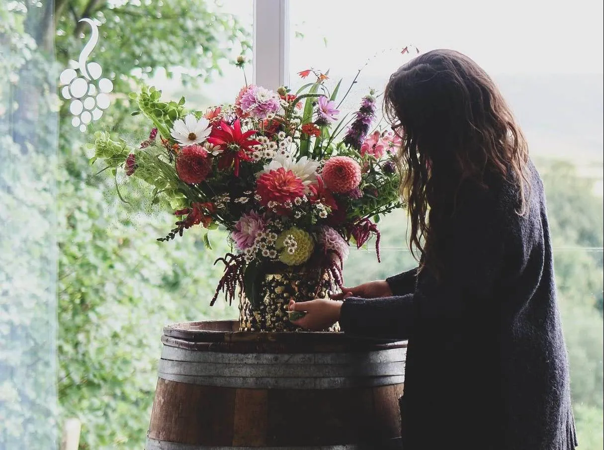 Arranging a large seasonal display of dahlias and cosmos
