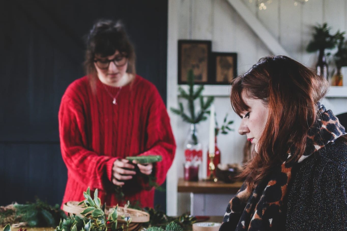 People at a table making Christmas wreaths
